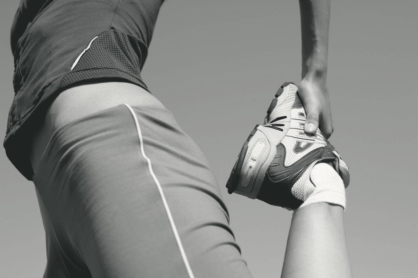 Athlete performing a quad stretch outdoors